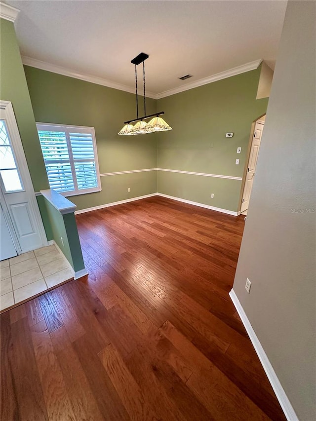 unfurnished dining area featuring wood-type flooring and ornamental molding