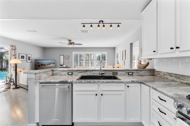 kitchen featuring sink, light hardwood / wood-style flooring, kitchen peninsula, white cabinets, and appliances with stainless steel finishes