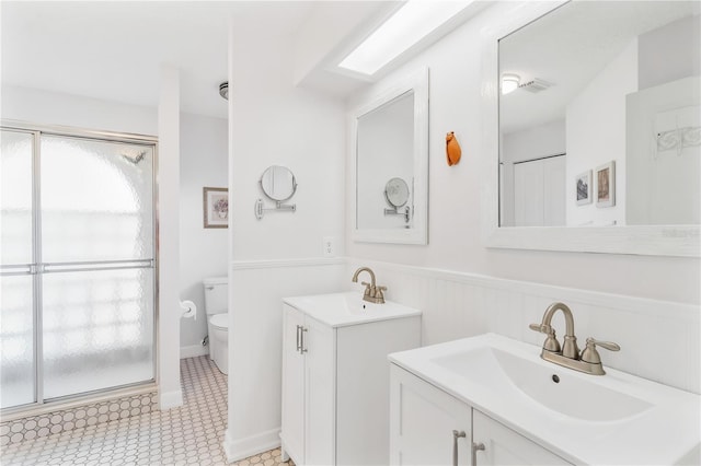 bathroom with walk in shower, tile patterned floors, vanity, and toilet