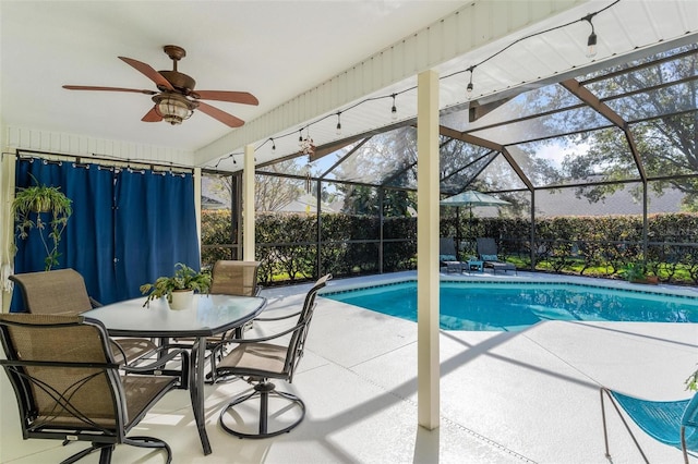 view of pool with glass enclosure, ceiling fan, and a patio area