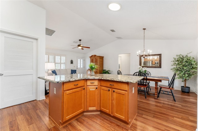 kitchen featuring light hardwood / wood-style floors, ceiling fan with notable chandelier, decorative light fixtures, a center island, and vaulted ceiling