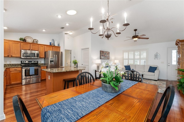 dining area featuring ceiling fan with notable chandelier, dark hardwood / wood-style flooring, and lofted ceiling