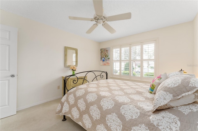 carpeted bedroom featuring a textured ceiling and ceiling fan