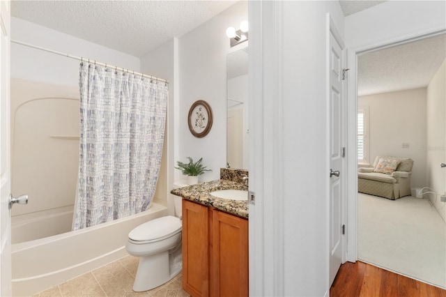 full bathroom featuring vanity, a textured ceiling, hardwood / wood-style flooring, toilet, and shower / bathtub combination with curtain