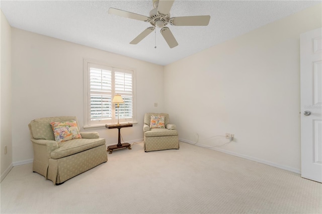 living area featuring ceiling fan, a textured ceiling, and carpet flooring