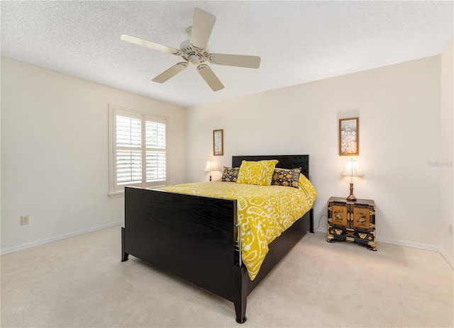 carpeted bedroom featuring a textured ceiling and ceiling fan