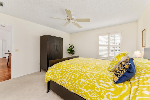 carpeted bedroom with a textured ceiling and ceiling fan