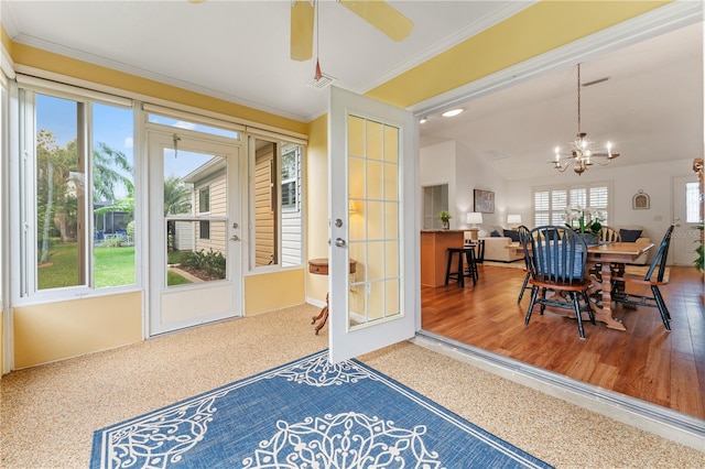 entryway with hardwood / wood-style floors, ceiling fan with notable chandelier, lofted ceiling, and crown molding