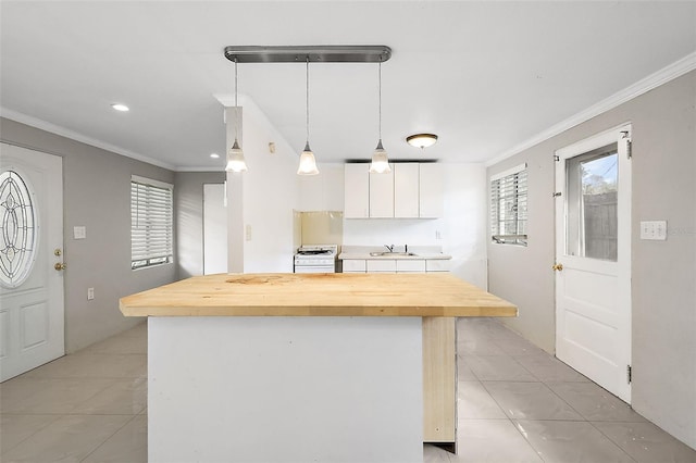 kitchen featuring white cabinets, white stove, pendant lighting, sink, and butcher block countertops