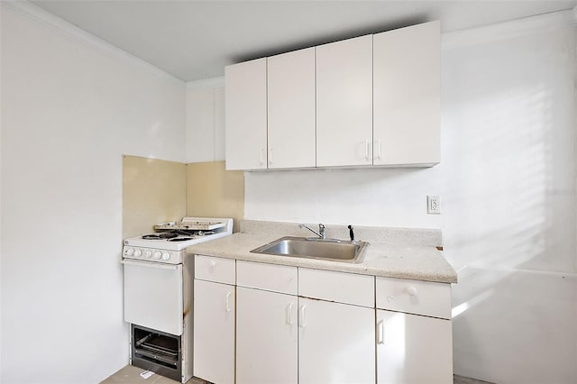 kitchen featuring ornamental molding, white cabinets, sink, and white range oven