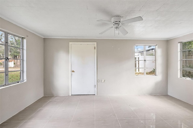 tiled spare room with crown molding, ceiling fan, and plenty of natural light