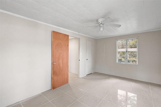 empty room featuring ornamental molding, light tile patterned floors, and ceiling fan