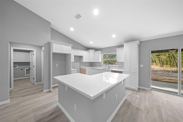 kitchen featuring a center island, light hardwood / wood-style flooring, white cabinetry, and sink