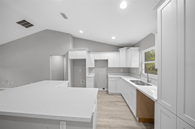 kitchen with sink, a spacious island, and vaulted ceiling