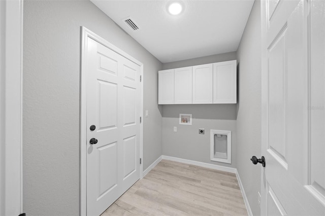 clothes washing area featuring electric dryer hookup, light hardwood / wood-style floors, cabinets, and hookup for a washing machine