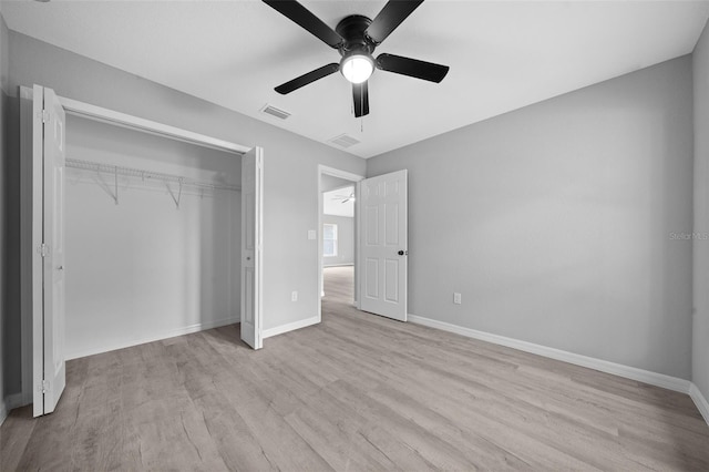 unfurnished bedroom with a closet, light hardwood / wood-style flooring, and ceiling fan