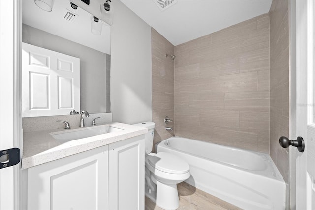 full bathroom with vanity, toilet, and tiled shower / bath