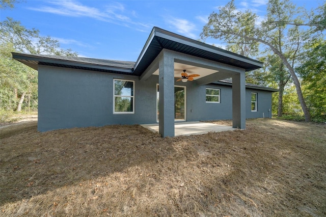 rear view of property featuring ceiling fan and a patio area