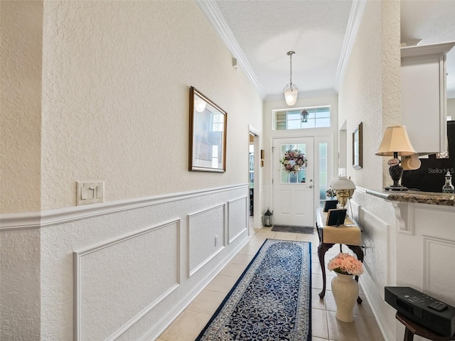 entrance foyer with light tile patterned flooring and crown molding