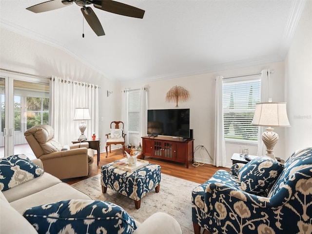 living room featuring hardwood / wood-style flooring, plenty of natural light, crown molding, and vaulted ceiling