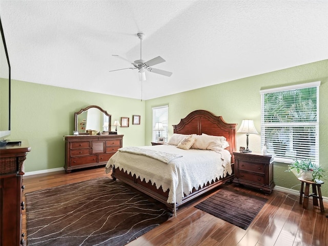 bedroom with multiple windows, a textured ceiling, dark hardwood / wood-style flooring, and ceiling fan