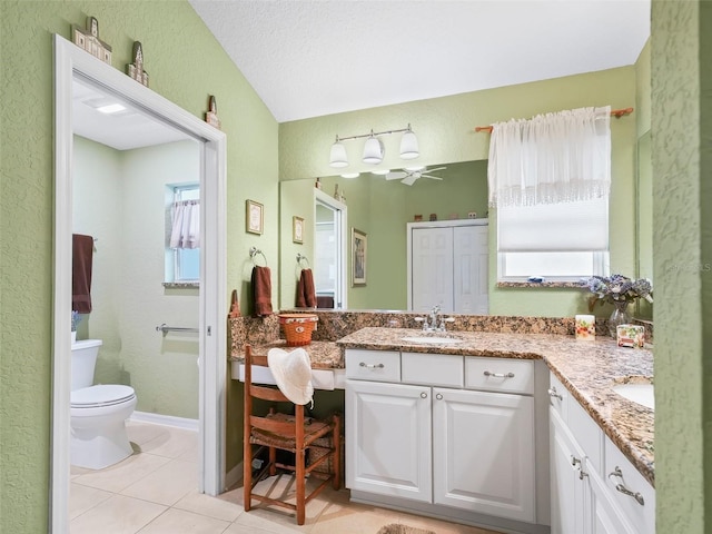 bathroom featuring toilet, vanity, tile patterned floors, and a healthy amount of sunlight