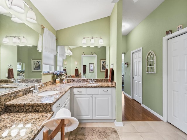 bathroom featuring hardwood / wood-style floors, vanity, and lofted ceiling