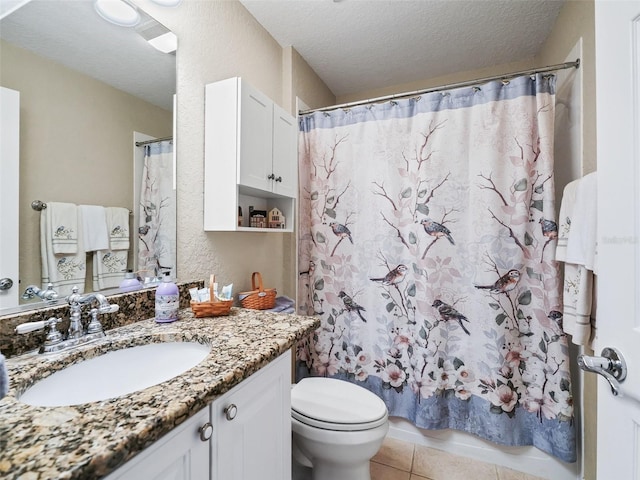 bathroom with vanity, a textured ceiling, tile patterned floors, and toilet