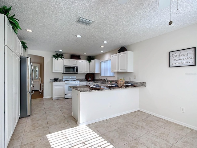 kitchen featuring white cabinetry, kitchen peninsula, appliances with stainless steel finishes, and a textured ceiling