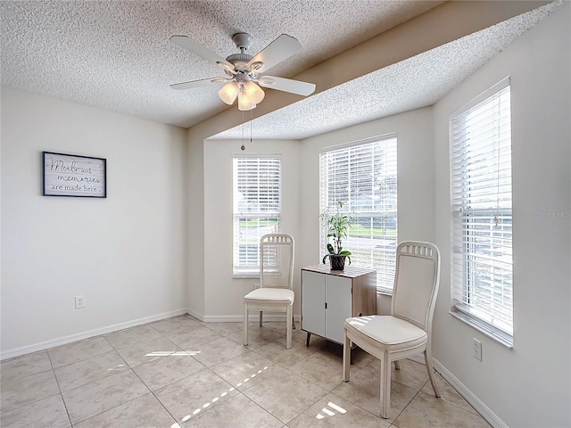 living area featuring ceiling fan, a textured ceiling, and light tile patterned floors