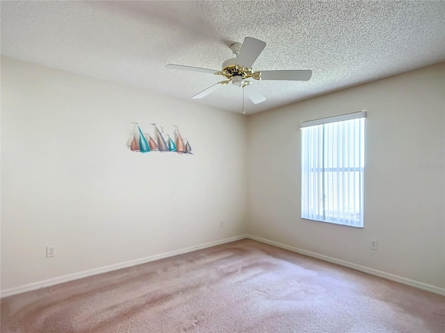 spare room featuring a textured ceiling, light colored carpet, and ceiling fan