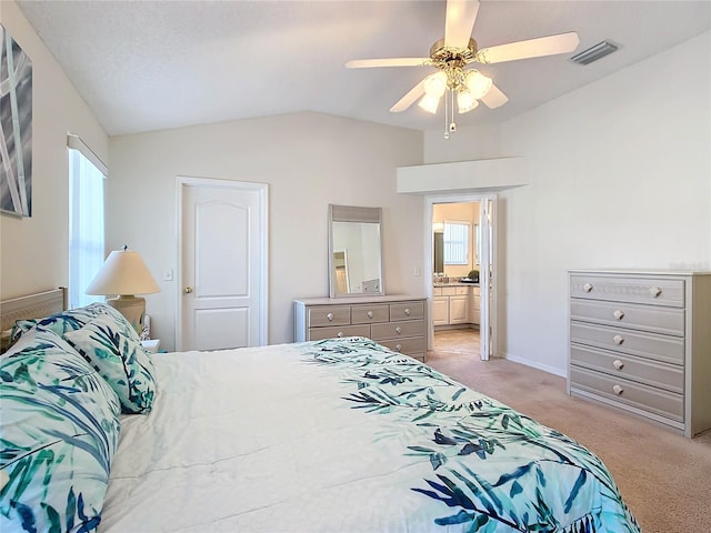 carpeted bedroom with ceiling fan, ensuite bath, and lofted ceiling