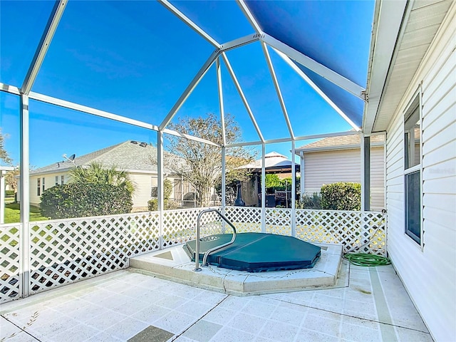 view of patio featuring glass enclosure and a covered hot tub