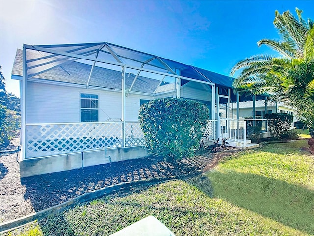 back of property with a lanai and a yard