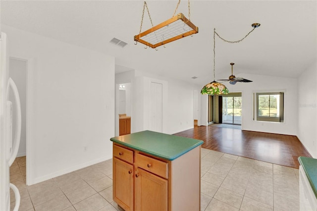 kitchen with light hardwood / wood-style floors, lofted ceiling, a center island, ceiling fan, and white fridge