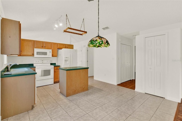 kitchen featuring sink, light tile patterned floors, white appliances, a center island, and vaulted ceiling