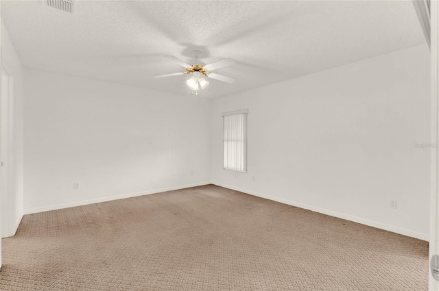 spare room with a textured ceiling, carpet floors, and ceiling fan