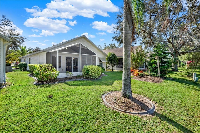 rear view of house with a sunroom, a lawn, and cooling unit