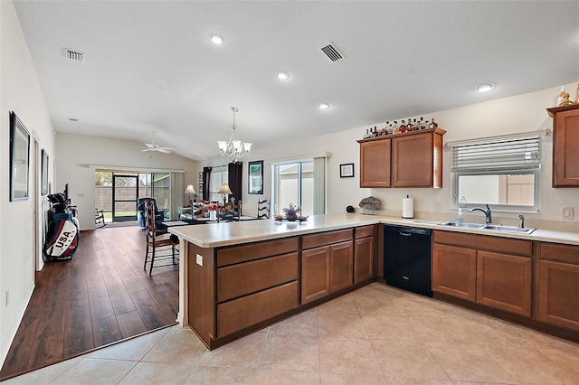 kitchen featuring dishwasher, lofted ceiling, sink, hanging light fixtures, and kitchen peninsula