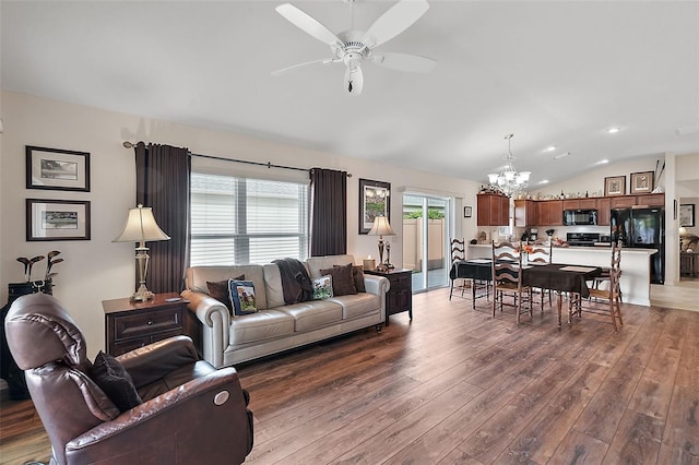 living room with lofted ceiling, wood-type flooring, and ceiling fan with notable chandelier