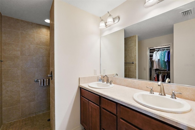 bathroom featuring a tile shower and vanity