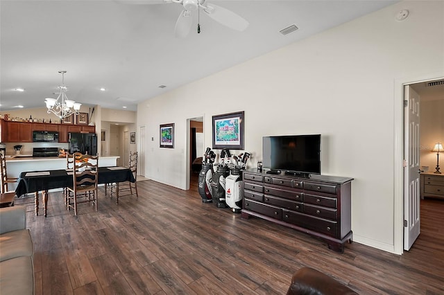 living room with vaulted ceiling, dark hardwood / wood-style flooring, and ceiling fan with notable chandelier