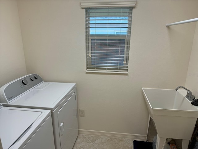 washroom with sink, independent washer and dryer, and light tile patterned flooring