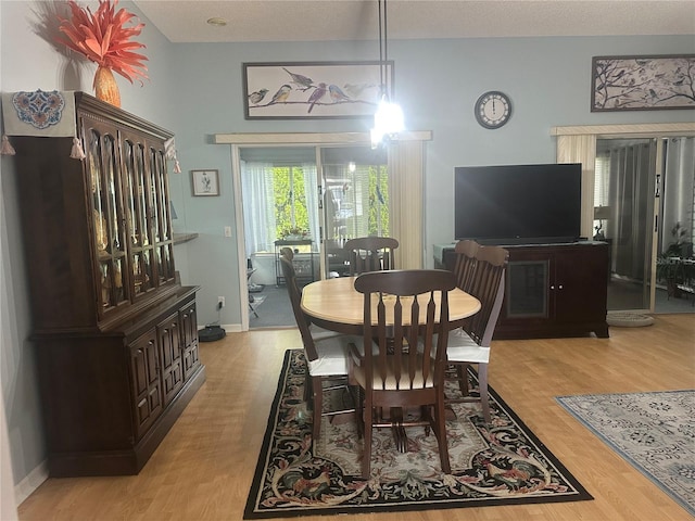 dining room featuring a textured ceiling and light wood-type flooring