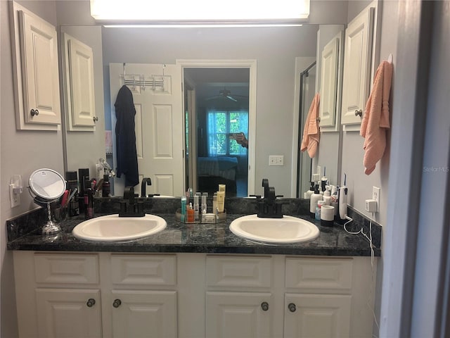 bathroom with walk in shower, vanity, and ceiling fan