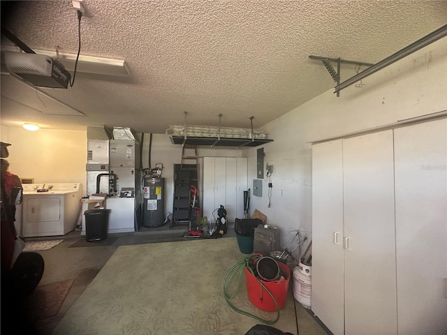 garage featuring water heater, washing machine and dryer, and a garage door opener