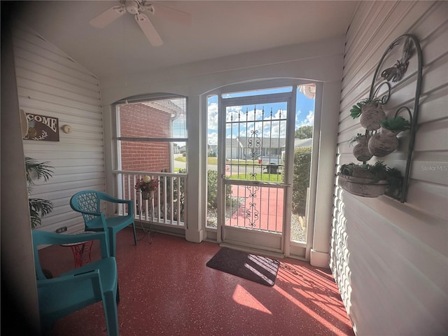 sunroom / solarium featuring lofted ceiling and ceiling fan