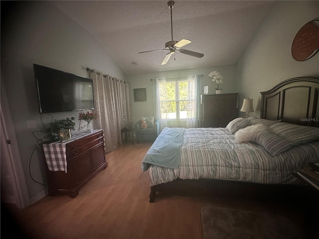 bedroom featuring light wood-type flooring, vaulted ceiling, ceiling fan, and a textured ceiling