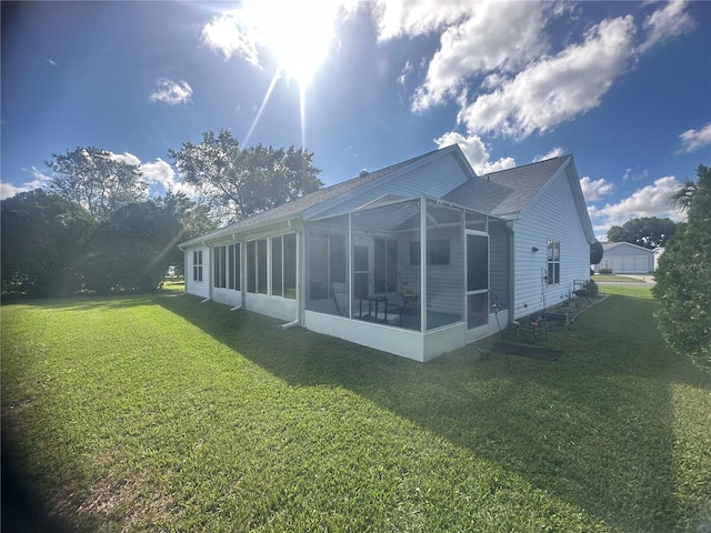 back of property featuring a sunroom and a yard