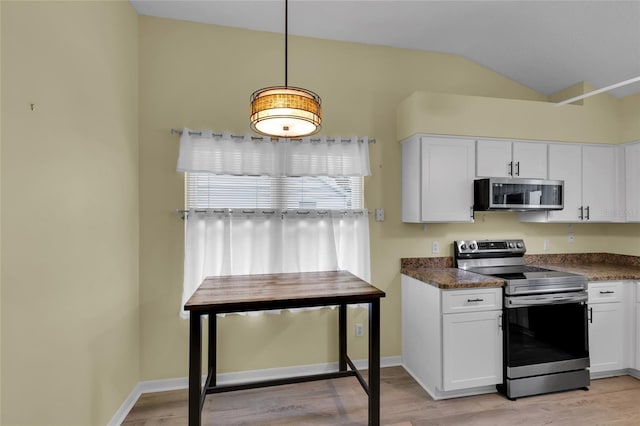 956 Chula Ct, The Villages, FL 32159 - kitchen with light wood-style floors, appliances with stainless steel finishes, dark countertops, and vaulted ceiling